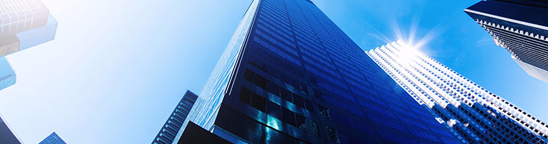 The tops of city buildings from the point-of-view of a pedestrian looking up.